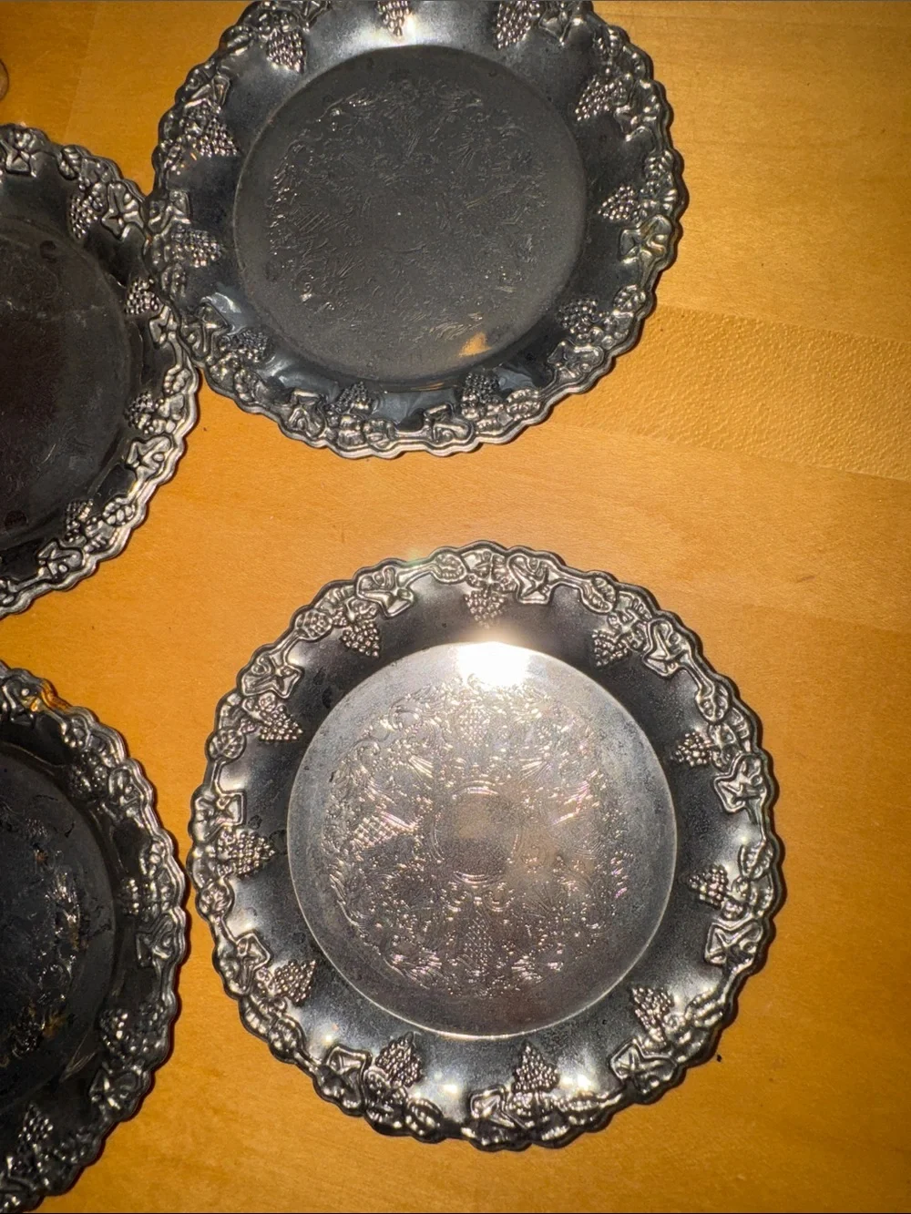 six vintage silver-plated drink coasters with ornate, embossed floral